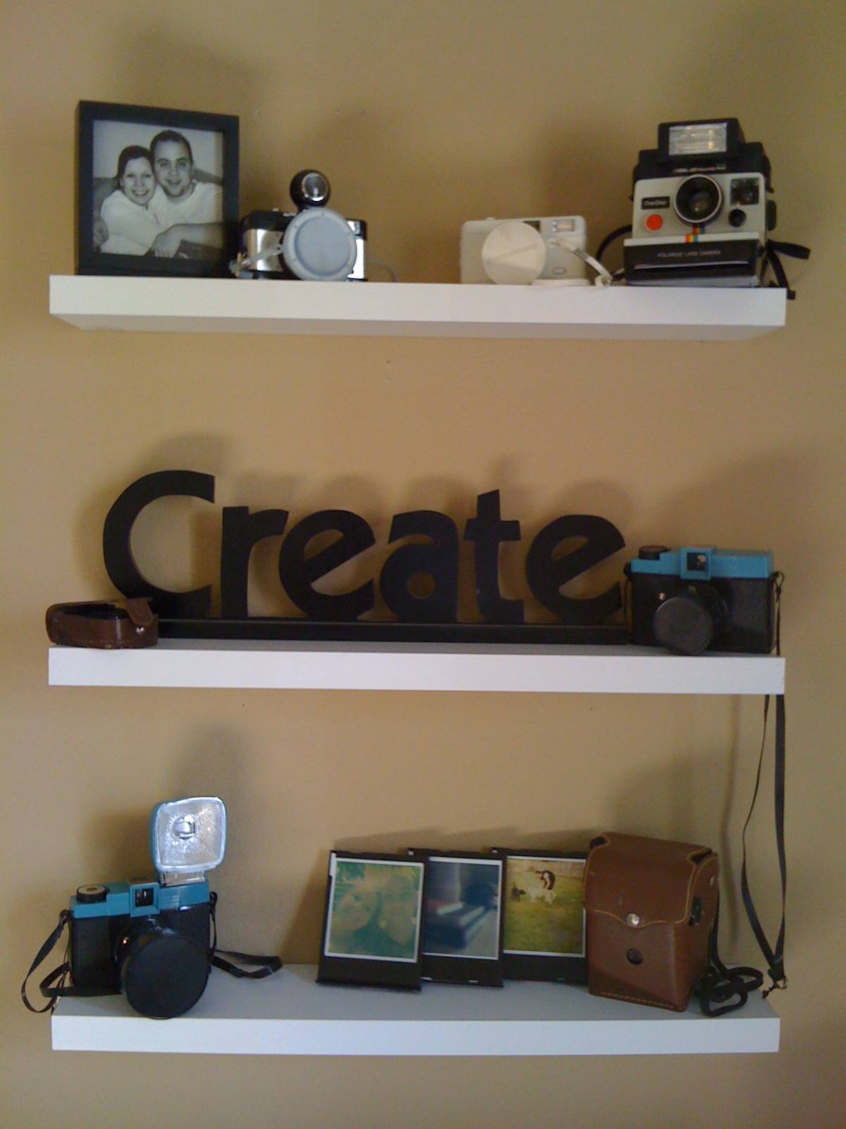 White shelves with vintage cameras and Polaroids